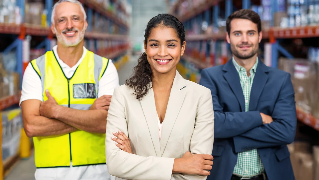 Employees standing and smiling. 