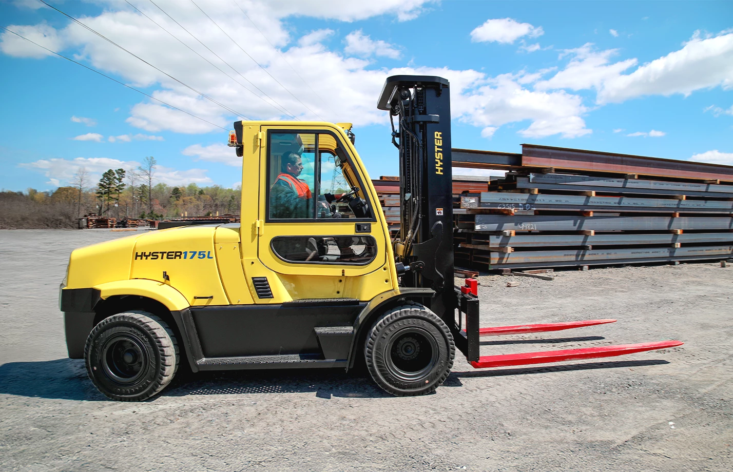 Hyster high-capacity electric lift truck approaching steel beams to transport. 