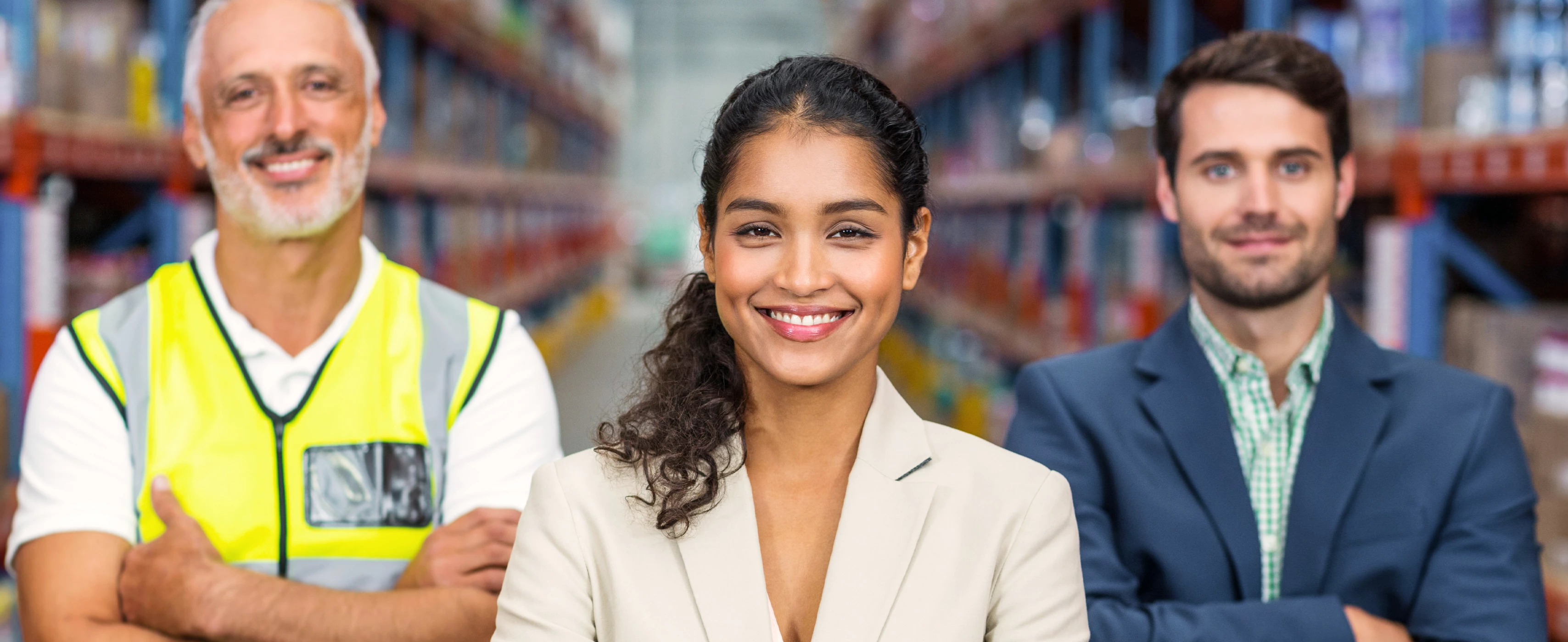 Employees standing and smiling.