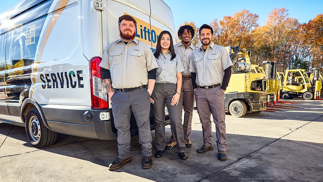 Lift truck technicians standing and smiling.