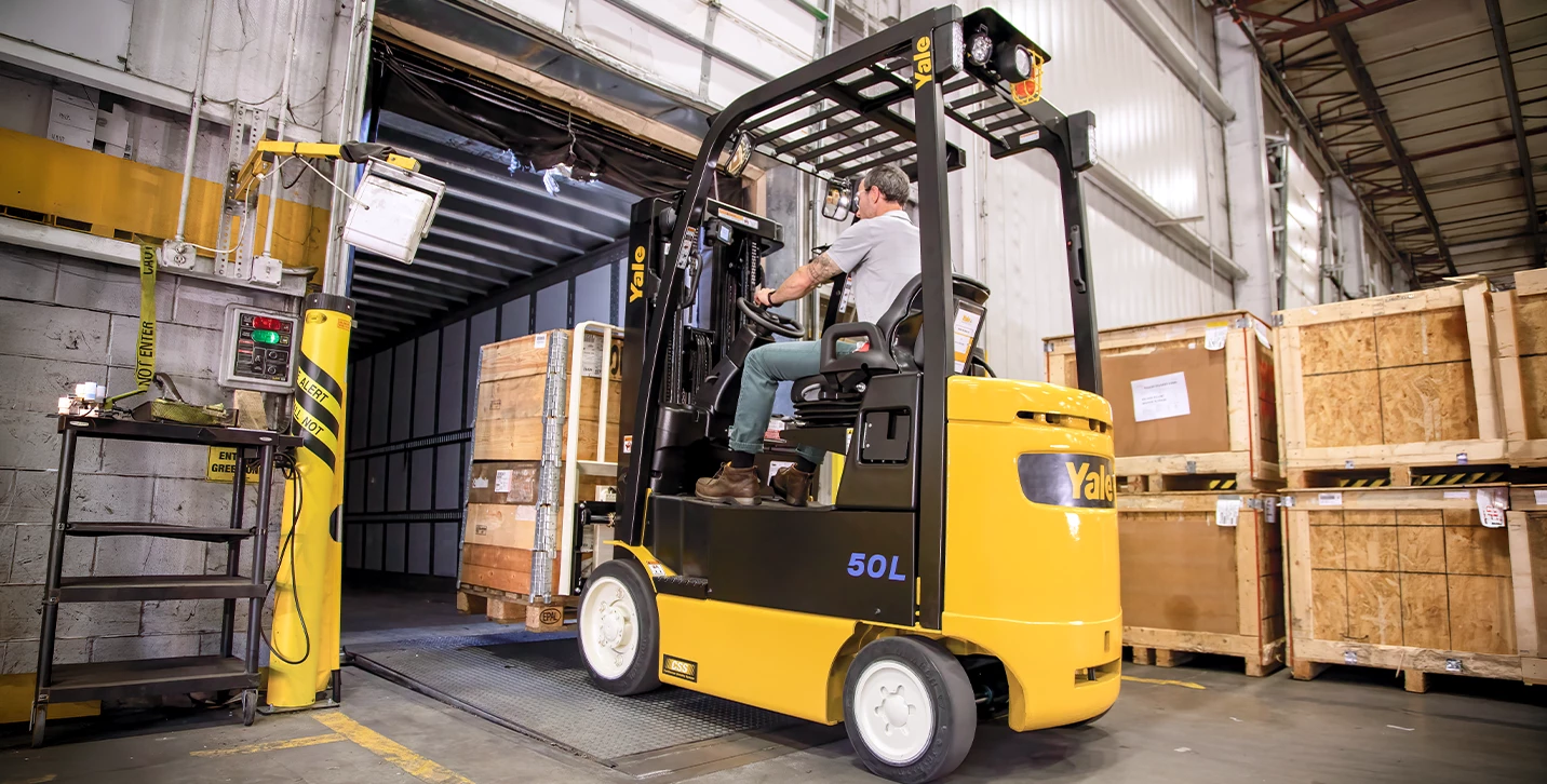 Operator driving electric Yale forklift into a trailer.